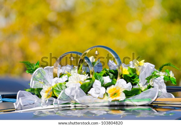 two big rings with bells and flowers as a car\
wed decoration