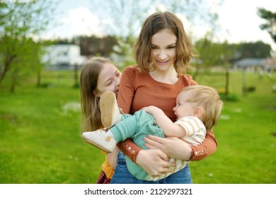 Two Big Sisters And Their Toddler Brother Having Fun Outdoors. Two Young Girls And A Baby Boy On Summer Day. Children With Large Age Gap. Big Age Difference Between Siblings. Big Family.