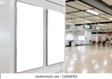 Two big vertical / portrait orientation blank billboard on modern white wall with concourse background