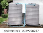 Two big water tank installed outdoor for storage freshwater or rainwater to use in house or accommodation during summer or drought. Made of special grade material, extra thick, UV protection, no moss.