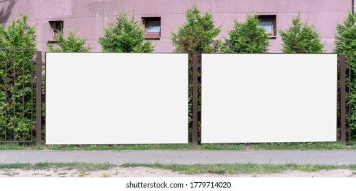 two big white empty banners hanging on metal fence outside with blank mock-up for commercial information rental housing concept