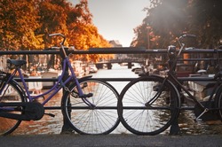 Two Bikes On A Bridge Over A Canal In Amsterdam (Netherlands)