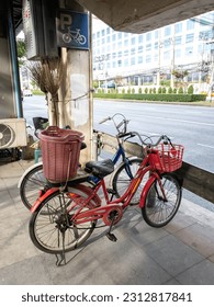 two bikes parked in the bike park which has a sign Parked on the footpath, on the side of the road, under the overpass.