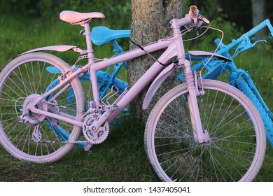 Two bikes parked next to a tree
