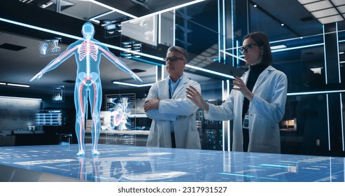 Two Bioengineers Working With Computer-Powered VFX Hologram Of Human Body And Organs In Futuristic Lab. Man And Woman Researching Blood Flow, Developing Innovative Technological Healthcare Solutions.