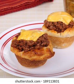 Two Biscuits With Sloppy Joe Meat And Melted Cheese On A Plate