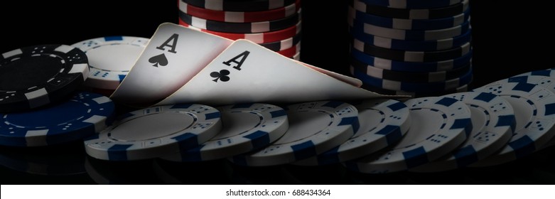Two black aces on poker cards glow in a dark casino - Shutterstock ID 688434364