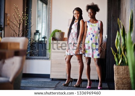 Two black african girlfriends at summer dresses, higheels posed in modern house. Stock photo © 
