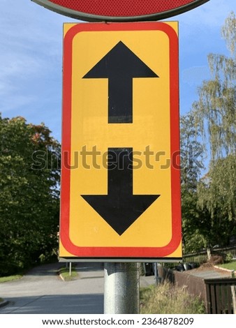 Two black arrows pointing up and down on Trafficsign.