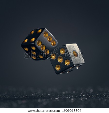 Two black dice are falling on a dark gray background.