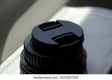 two black DSLR camera lens caps with a blurred background - Powered by Shutterstock