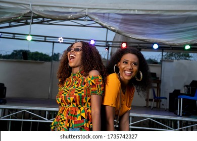 Two Black Girls Dancing At A Concert Held At Night