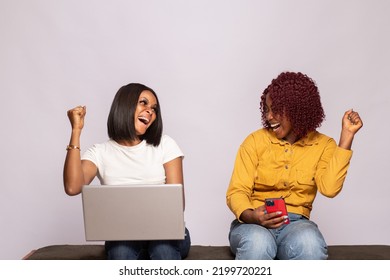 Two Black Girls Using Their Phone And Laptop Rejoice