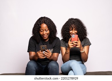 Two Black Girls Using Their Phones