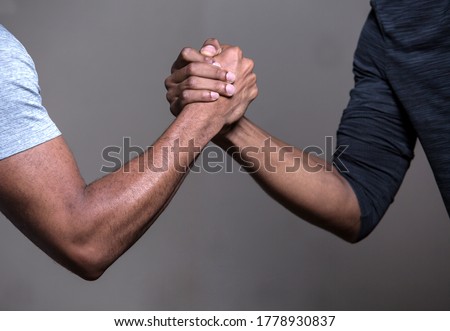 Two black hands locked in a clasp, symbol of friendship, brotherhood, help, cooperation
