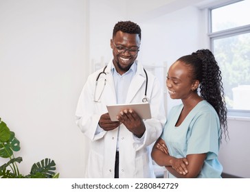 Two Black healthcare professionals discuss patient case on digital tablet  - Shutterstock ID 2280842729