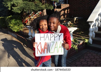 Two Black Kids Holding Happy Kwanzaa Outside Urban Home