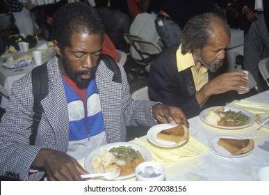 Two Black Men Eating Christmas Dinner At Homeless Shelter, Los Angeles, California