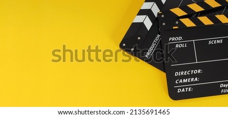 Two Black and yellow Clapper board or movie slate.it use in video production ,film, cinema industry on yellow background.