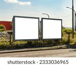 Two blank billboard mockups next to each other. Advertisement template next to a street in an industry district of a big city. The space is free to insert any graphics. The road is empty.