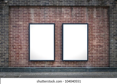 Two Blank Billboards Attached To A Buildings Exterior Brick Wall.