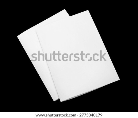 Two blank folded paper sheets, isolated on black background