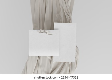 Two blank sheets of paper on background with beige satin material, with one bow in upper side of paper on left paper and on top of second piece of paper. 3d rendering
