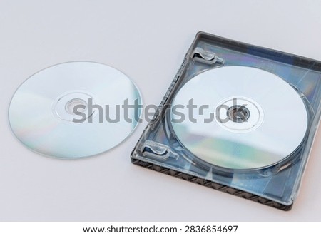 Two blank silver optical discs are displayed with a transparent media case