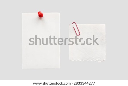 Two blank white paper notes fastened with a red push pin and paperclip, blank rectangular memo notes pinned and clipped