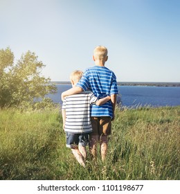 Two Blond Boys Hugging And Looking Into The Distance. Conceptual Realism. Nature And People.