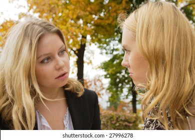 Two Blond Girls Having Serious Conversation Outdoors