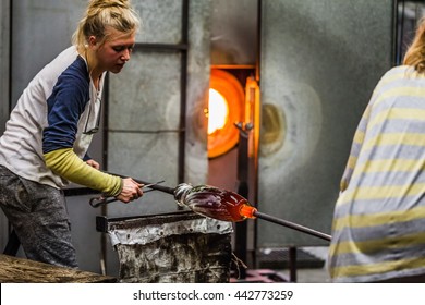 Two Blowing Glass Artists Finishing a beautiful Piece.