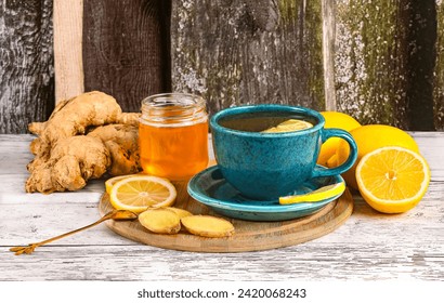 Two blue cups and ingredients for ginger tea, honey, lemons, ginger root on wooden background, side view - Powered by Shutterstock