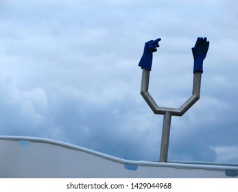 Two Blue Plastic Gloves On Metal Contraption On Fishing Boat In Southern Danish Harbour