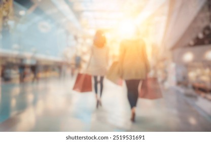 Two blurry figures, carrying shopping bags, walk through a bright shopping mall. - Powered by Shutterstock