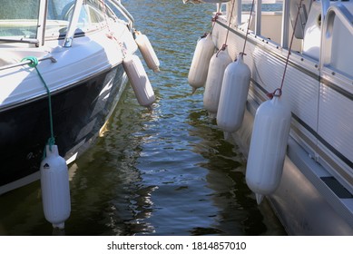 Two boats at dock, with protector ballasts.