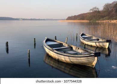 two boats floating on a quiet winter day in Denmark during sunset. - Powered by Shutterstock