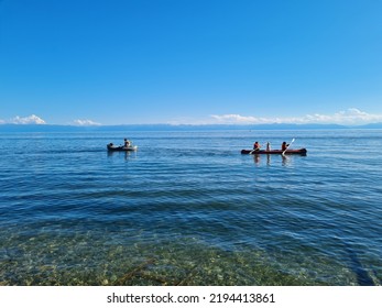 Two Boats With People And Dogs On Lake Baikal In August.