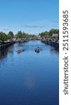 Two Boats Rowing on the River in Kilkenny: A Serene Scene of Gentle Watercraft Gliding Through the Scenic Waterways, Reflecting the Tranquil Charm of Kilkenny