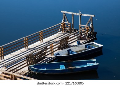 Two Boats Tied To A Wooden Pontoon