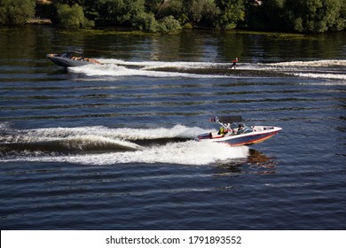 Two Boats Towing Athletes On The Boards On The Counter Courses. Athlete Water Skiing And Having Fun. Speed Boat For Surfing The Wakeboard. Water Skiing On Lake Behind A Boat. Top View.