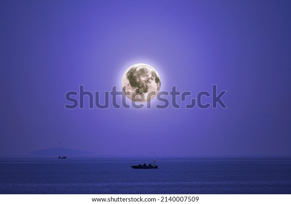 Two boats in water in\
the moonlight 