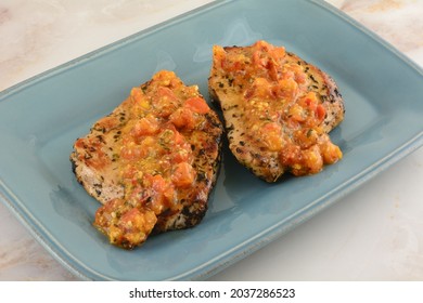 Two Boneless Pork Chops With Spicy Tomato And Red Pepper Sauce On Blue Serving Plate