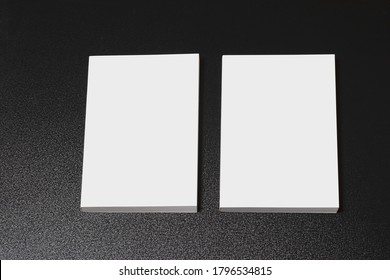 Two books with blank cover on dark glossy table, editable mock-up series ready for your design, cover selection path included. 