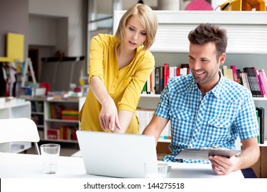 Two Bookshop Managers Working On Laptop.