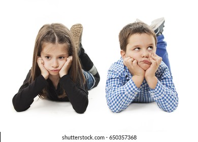 Two bored kids lying on the white background