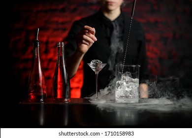 Two Bottles With Drink, Martini Glass With Ice And Mix Cup Stand On Smoky Bar