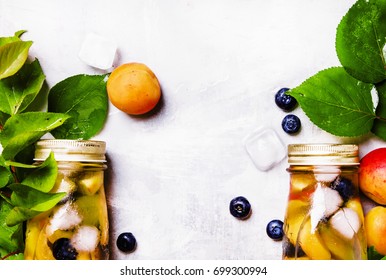 Two bottles with fruit tea with apricot, blueberry and ice, food background, top view