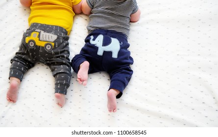 Two Bottom Parts And Cute Tiny Feet Of Twin Babies Lying Down. Tummy Time For Learning. Shot From Above With Free Space For Text. International Day For Protection Of Children