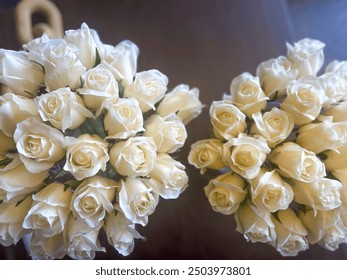 Two bouquets of white roses placed on a wooden surface, creating a classic and elegant floral arrangement. Suitable for weddings, celebrations, and romantic occasions. Ideal for florists, event planne - Powered by Shutterstock